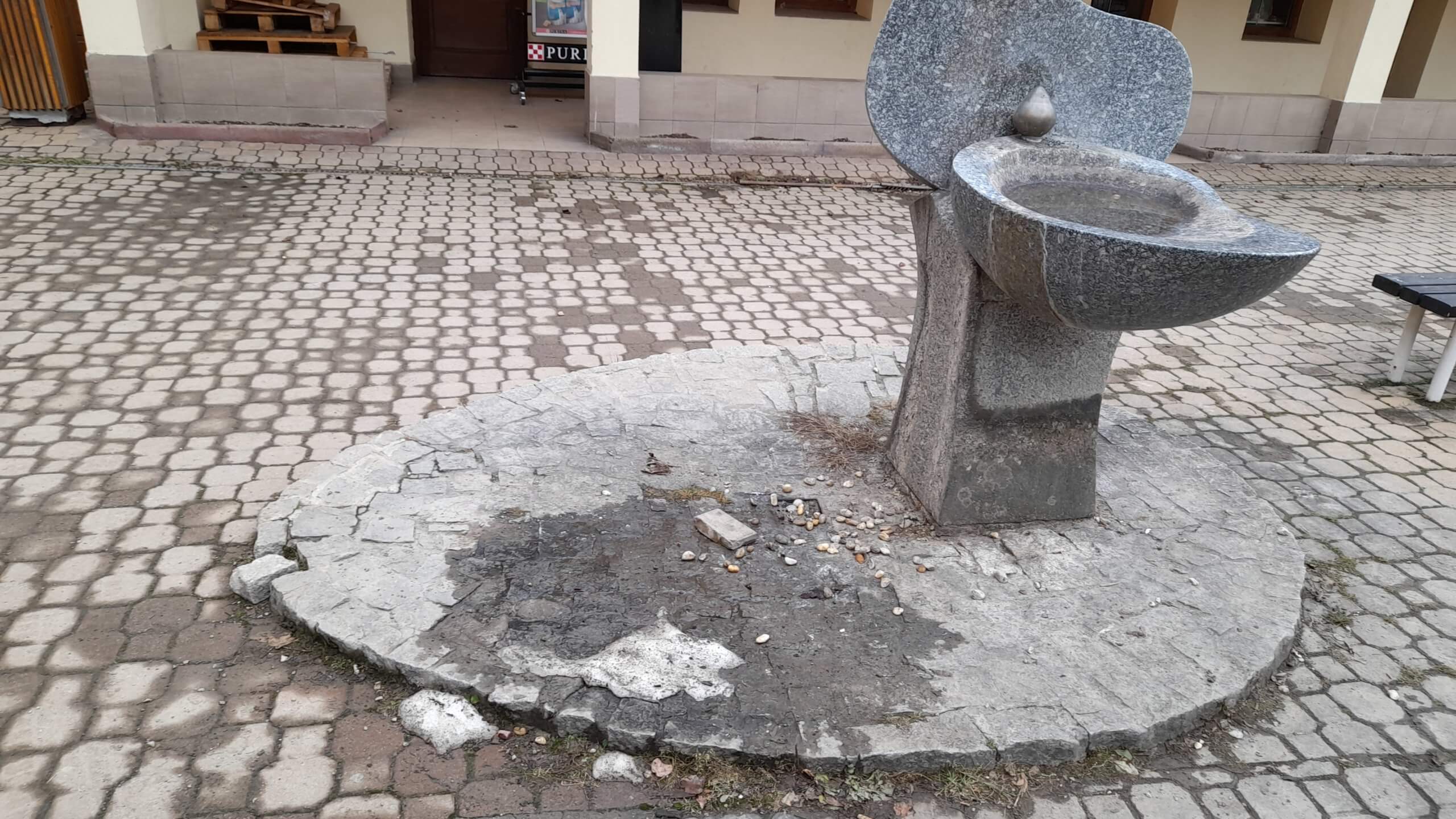 Nefunkční fontána a poškozené okolí